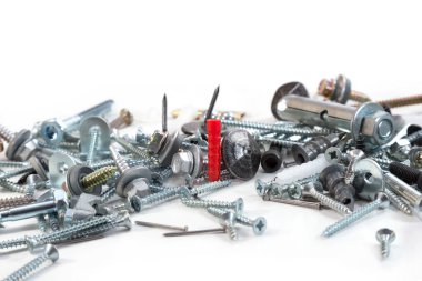 Farklı boyutlarda vidalar, cıvatalar, çiviler ve beyaz arka planda kırmızı bir panel.