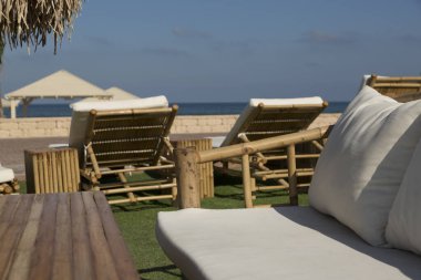 Deniz kıyısında, bambudan sıraları ve masaları olan dinlenebileceğim bir yer.