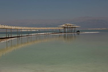 Sudaki yansıması Ölü Deniz 'e kadar uzanan bir güneş gölgesi.