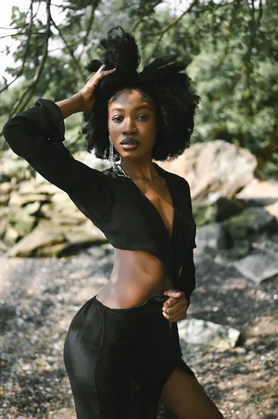 ファッション屋外ビーチの肖像画晴れた夏の日に岩や緑の木と砂浜の海岸に外をポーズ美しい若いアフリカ系アメリカ人の黒人女性 ナチュラルスキンケア — ストック写真