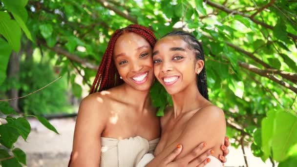 屋外の肖像画を閉じる美しい若いアフリカ系アメリカ人の女性の黒のカップル 完璧な白い歯の笑顔 姉妹の友人は晴れた夏の日に抱擁 スキンケア — ストック動画
