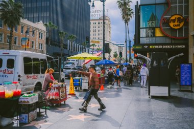16 Mart 2024, Los Angeles ABD. Hollywood Bulvarı Şöhret Bulvarı Tiyatro Bölgesi ünlü bir turistik merkezdir. Bir sürü insan ünlülerin yıldızlarıyla kaldırımda yürüyor.