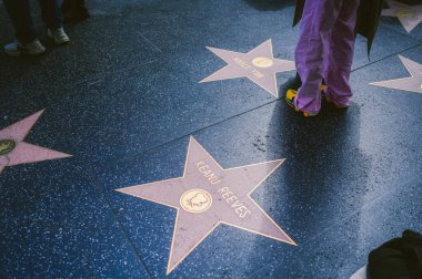 16 Mart 2024, Los Angeles ABD. Hollywood Bulvarı Şöhret Bulvarı Tiyatro Bölgesi ünlü bir turistik merkezdir. Bir sürü insan ünlülerin yıldızlarıyla kaldırımda yürüyor.