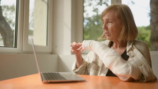 Ältere Frau Bei Einer Videokonferenz Mit Laptop Und Gebrochenem Arm — Stockvideo