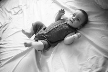 Sevimli, komik, yeni doğmuş küçük çocuk bej çarşaflarda ya da beşiğinde huzur içinde yatıyor. Bebek eşyaları paketleme şablonu. Sağlıklı çocuk, hastane kavramı ve mutlu annelik. Bebek, bebek. Çocuk odası..