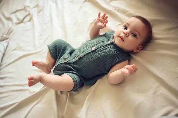Sevimli, komik, yeni doğmuş küçük çocuk bej çarşaflarda ya da beşiğinde huzur içinde yatıyor. Bebek eşyaları paketleme şablonu. Sağlıklı çocuk, hastane kavramı ve mutlu annelik. Bebek, bebek. Çocuk odası..