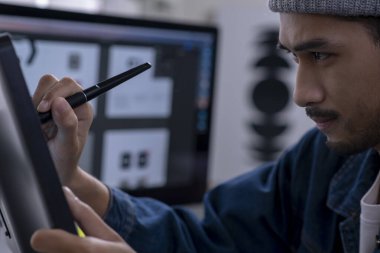 Asian male graphic designer working on computer drawing sketches logo design. The concept of a new brand. Professional creative occupation with idea.