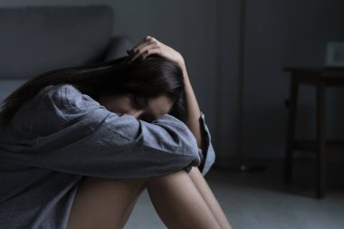 Yatak odasındaki genç Asyalı kadın üzgün, yorgun ve endişeli zihinsel sağlıkta depresyon yaşıyor.