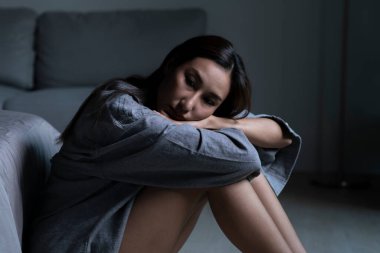 Yatak odasındaki genç Asyalı kadın üzgün, yorgun ve endişeli zihinsel sağlıkta depresyon yaşıyor.