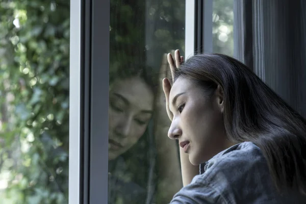 Портрет Сумної Стурбованої Азіатської Жінки Яка Дивиться Через Вікно Вдома Стокове Фото