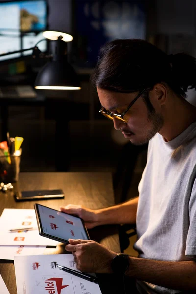 Asian man graphic designer working on computer drawing sketches logo design. The concept of a new brand. Professional creative occupation with idea.