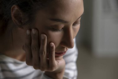 Asyalı bir kadının üzgün, üzgün, endişeli, hayal kırıklığına uğramış, evde zihinsel hastalıktan yapayalnız yüzünün yakın çekimi. Kadın zihinsel sağlık sorunları yaşıyor.