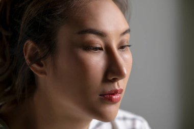 Asyalı bir kadının üzgün, üzgün, endişeli, hayal kırıklığına uğramış, evde zihinsel hastalıktan yapayalnız yüzünün yakın çekimi. Kadın zihinsel sağlık sorunları yaşıyor.