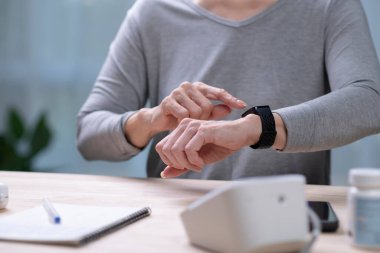 Kıdemli Asyalı Kadın, akıllı insanlar üzerinde tansiyon testi yaptırıyor..