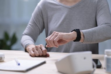 Kıdemli Asyalı Kadın, akıllı insanlar üzerinde tansiyon testi yaptırıyor..