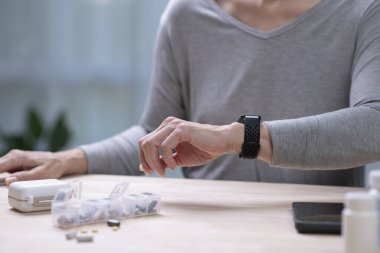 Kıdemli Asyalı Kadın, akıllı insanlar üzerinde tansiyon testi yaptırıyor..