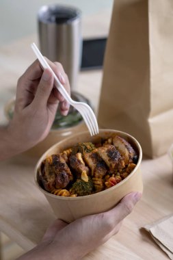 Kâğıt kaseyi sağlıklı yiyeceklerle kapatıyoruz genç adam, çalışırken sağlıklı yemek yiyen kadın, iş adamı ofiste ya da evde öğle yemeği molası veriyoruz.