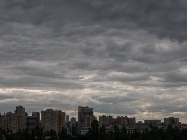 Ufukta gökdelenler ve Kyiv şehri üzerinde fırtına bulutları olan karanlık bir gökyüzü. Ukrayna 'da karanlık bir günde sanayi şehri.