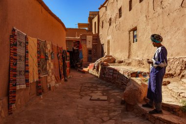 North Africa. Morocco. Ksar Ait Benhaddou in the Atlas Mountains of Morocco. UNESCO World Heritage Site since 1987. A carpet seller in a alley of the medina