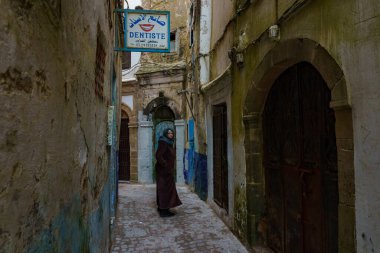 Fas 'ta. Essaouira. Djellaba giymiş üç kadın Medine 'de bir caddede yürüyor.