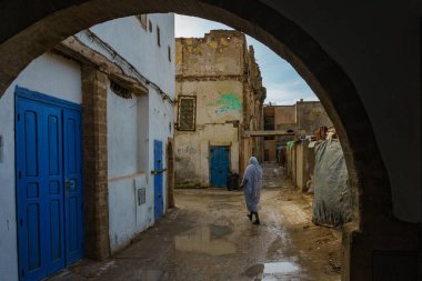 Fas 'ta. Essaouira. Djellaba giymiş üç kadın Medine 'de bir caddede yürüyor.