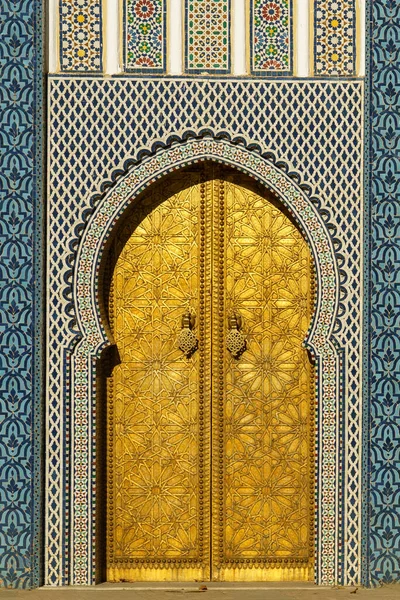 モロッコ フェズ 1320年にメリニッド家によって設立された王宮前の観光客のカップル 1970年頃に地元の職人によって作られた銅製の巨大な扉を通してアラオライト広場にオープンします — ストック写真