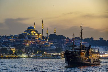 Hindi. İstanbul. Günbatımında arkaplanda Süleyman Camii 'nin olduğu Boğaz' da bir yolcu gemisi