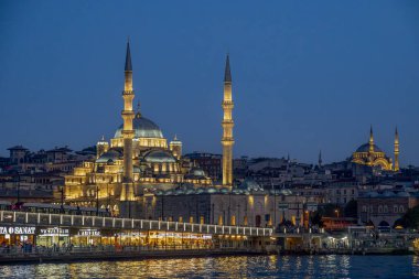 Hindi. İstanbul. Yeni Cami Camii, Galata köprüsü ve arka planda Süleyman Camii ile aydınlandı.