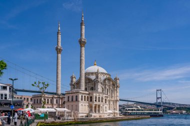 Hindi. İstanbul. Ortakoy Camii 'nin önüne mavi gökyüzünün altına bir yolcu gemisi yanaşıyor.