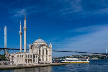 Hindi. İstanbul. Ortakoy Camii 'nin önüne mavi gökyüzünün altına bir yolcu gemisi yanaşıyor.