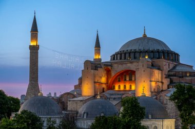 Turkiye. Istanbul. The Hagia Sophia mosque lit up at dusk under a beautiful blue sky clipart