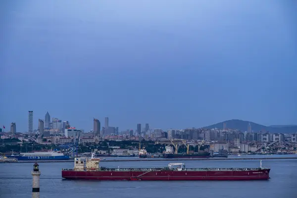 İstanbul. Hindi. Asya kıtasının modern bölgeleriyle birlikte büyük bir kargo gemisi Boğazı 'ndan geçiyor.