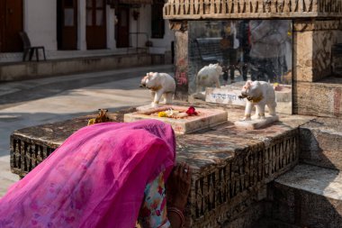 Hindistan. Rajasthan. Udaipur. Jagdish Tapınağı. Hintli bir kadın Hindu tanrısı Vishnu 'nun ayak izlerinin önünde dua eder.