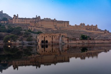 Hindistan. Rajasthan. Jaipur. Amber Kalesi. Kalenin genel manzarası alacakaranlıkta Maotha Gölü 'ne yansıdı.