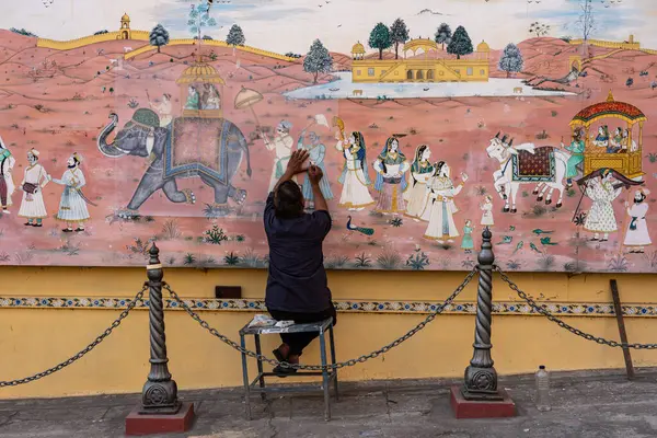 Hindistan. Rajasthan. Jaipur. Amber Kalesi. Hintli bir ressam, Amber 'da bir sokakta duvar freskini restore ediyor.
