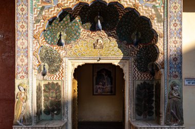 Hindistan. Rajasthan. Jaipur. Şehir Sarayı. Tavus kuşu motifleriyle süslenmiş Tavus kuşu Kapısı 'nın mimari ayrıntıları sonbaharı sembolize eder ve Tanrı Vishnu' ya adanmıştır. Chandr 'ın iç avlusundaki Ridhi Sidhi Pol olarak bilinen dört kapıdan biri.