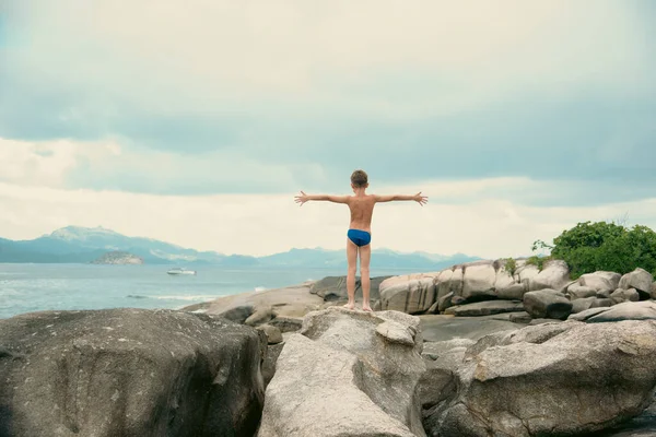 男孩手拉手站在美丽的热带海滩上 背景是花岗岩岩石和岛屿 — 图库照片