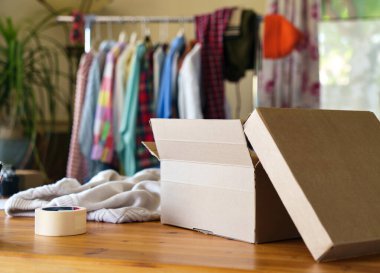 İçinde giysiler olan paket masanın üzerinde. Sürdürülebilir moda, yeniden satış giysileri, kıyafet kiralama