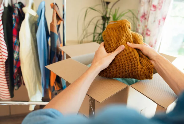 stock image Pov view of man packing clothes into box for resale or donation.