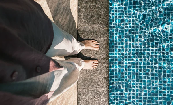 Person standing on the edge of swimming pool, top view