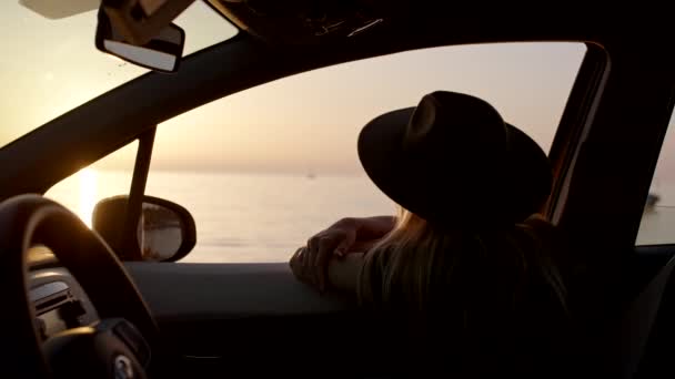 ロードトリップ中に車の窓から夕日を楽しむ女性 — ストック動画