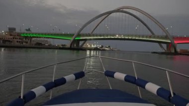 Yacht sailing at Dubai Creek at sunset. 