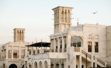 Beautiful sandstone building and flying seagulls at Al seef in Dubai heritage district.