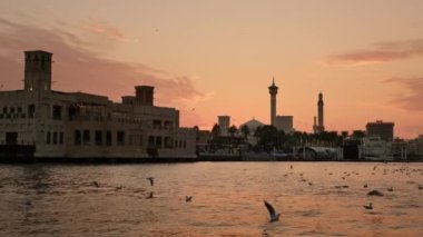 Gün batımında Dubai Creek 'te rıhtım manzarası