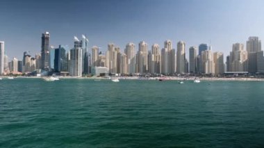 Dubai Marina gökdelenleri ve lüks binaları ve tatil köyleri olan JBR bölgesi. Kanalda yelken açan yatları olan liman bölgesi. Yazı 1 Ocak 2023, Dubai, BAE