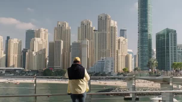Seorang Pria Berdiri Pinggir Laut Dengan Pemandangan Menghadap Pantai Jumeirah — Stok Video