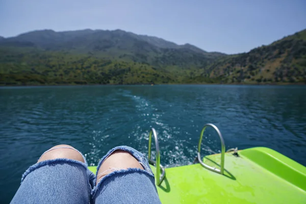First person view at lake and female legs from pedal boat at lake of Kournas, Crete.
