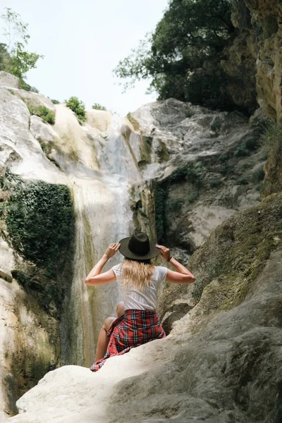 在尼德里瀑布 戴着帽子的年轻女子坐在岩石上 欣赏美丽的大自然 希腊爱奥尼亚群岛Lefkada — 图库照片