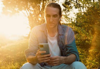 Açık havada akıllı telefon kullanan Kafkasyalı Neşeli Adam Portresi 