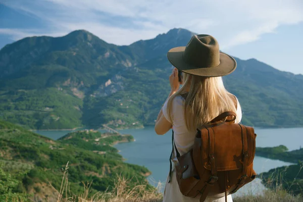 Woman Photographer Big Backpack Taking Photo Mountains Blue Lake Travel lizenzfreie Stockbilder